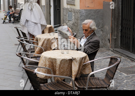 Acquapendente, Italia, uomo seduto in una street cafe quotidiano di lettura Foto Stock