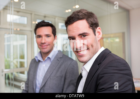Ritratto di due imprenditori sorridente in ufficio, guardando la fotocamera Foto Stock