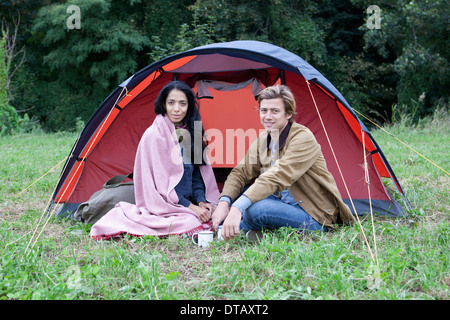 Coppia giovane seduto vicino a tenda a cupola, ritratto Foto Stock