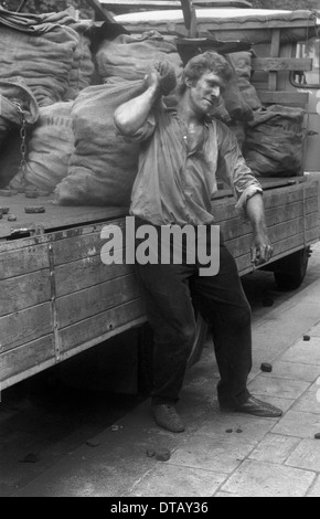 Venditore di carbone che porta un sacco pieno di carbone, Berlino, RDT Foto Stock
