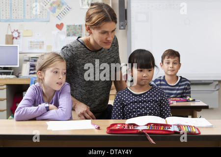 Maestro che insegna agli studenti in aula Foto Stock