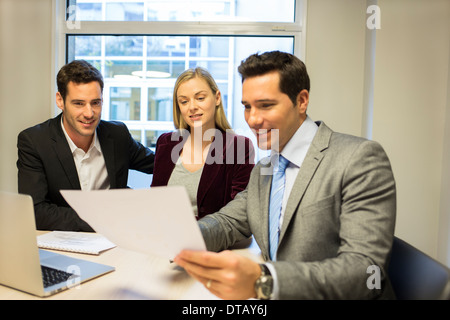 Immobili che mostra il contratto alla coppia giovane, nuovi proprietari Foto Stock