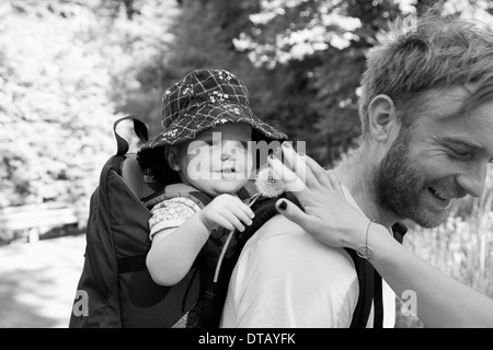 Padre che porta il suo figlio in baby carrier Foto Stock