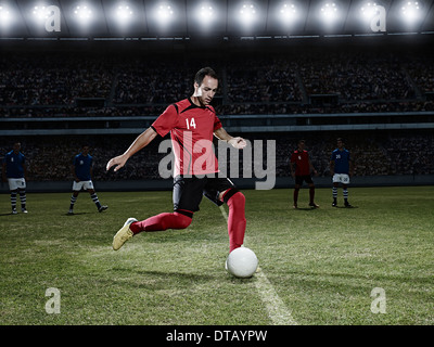 Giocatore di calcio calci palla sul campo Foto Stock