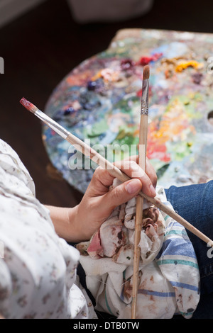 Artista femminile tenendo il pennello, close-up Foto Stock