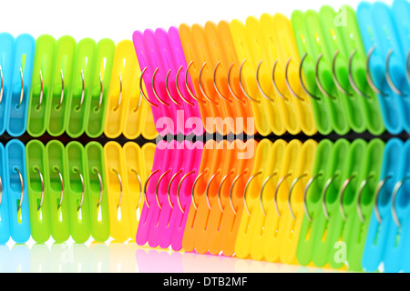 In plastica colorata clothespin su sfondo bianco Foto Stock
