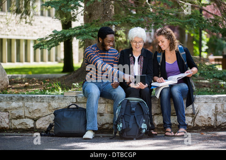 Felice gli Studenti Universitari con tavoletta digitale del Campus Foto Stock