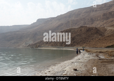 La gente camminare lungo il litorale del Mar Morto Israele Foto Stock