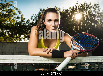 Femmina giocatore di tennis Racchetta tenuta appoggiata sul net Foto Stock