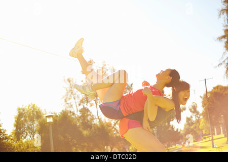 Due giovani donne di divertirsi nel parco Foto Stock