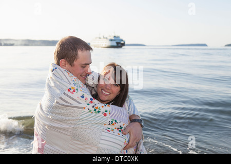 Coppia giovane avvolto in una coperta a costa Foto Stock