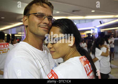 Pattaya, Thailandia. 14 Fabruary 2014. Un giovane, Tedesco Jens Hotze e tailandese Siriporn Buakla abbracciarsi nel tentativo di rompere il Guinness World Record per la più lunga maratona abbracciando come parte del prossimo il giorno di San Valentino celebrazioni in Pattaya. Il "mondi più lunga maratona abbraccia' su il giorno di San Valentino in Pattaya organizzato da Crederci o no di Ripley. Venti-sei coppie fatte i nuovi mondi più lunga maratona abbraccia' a 26 ore 26 minuti 26 secondi. Credito: John Vincent/Alamy Live News Foto Stock