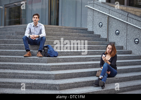 Infelice giovane seduta oltre a passi Foto Stock