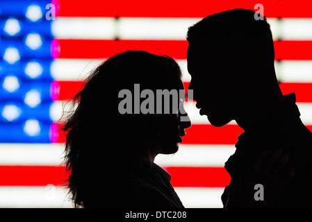 Silhouette di coppia giovane nella parte anteriore della bandiera americana Foto Stock