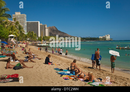 La gente sulla sabbia presso la spiaggia di Waikiki, Honolulu Oahu, Hawaii Foto Stock