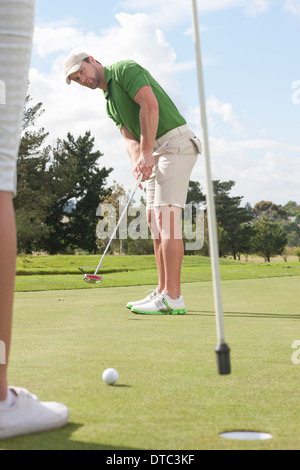 Giovane maschio golfista mettendo sul golf green Foto Stock