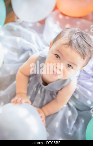 Bambina indossa abiti di partito con palloncino Foto Stock