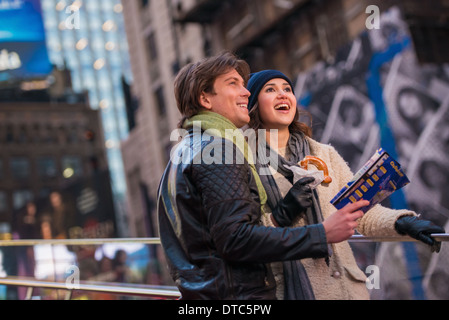 Una giovane coppia in vacanza con mappa e bagel, New York City, Stati Uniti d'America