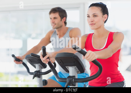 Determinata giovane che lavora fuori alla classe di filatura in palestra Foto Stock