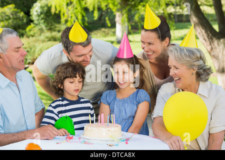 Famiglia estesa indossando cappelli partito alla festa di compleanno in posizione di parcheggio Foto Stock