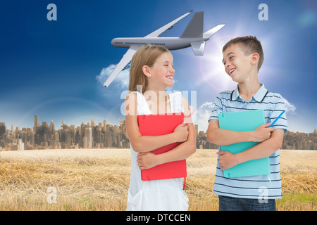 Immagine composita di sorridere fratello e sorella di tenere i loro libri di esercizio Foto Stock