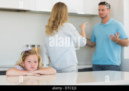 Ragazza triste appoggiata sul tavolo mentre i genitori sostenendo Foto Stock