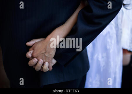 Tijuana, Messico. 14 feb 2014. Un giovane tiene le mani durante un collettivo di cerimonia di nozze su il giorno di San Valentino nella città di Tijuana, Messico, 14 febbraio, 2014. Credito: Guillermo Arias/Xinhua/Alamy Live News Foto Stock