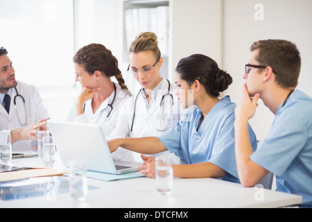 Medico e infermiere discutendo su laptop Foto Stock