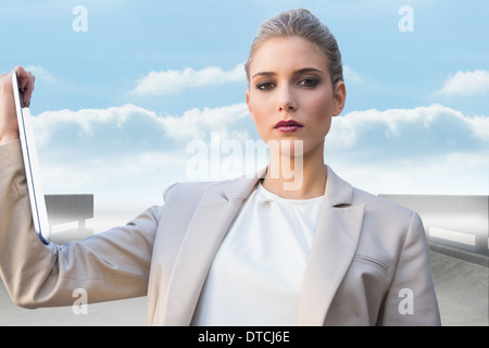 Immagine composita di gravi classe imprenditrice azienda tablet Foto Stock