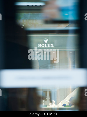 La vetrina del negozio di un Rolex Swiss luxury watch shop su Zurigo Bahnhofstrasse sta sparendo dietro il passaggio di un tram Foto Stock