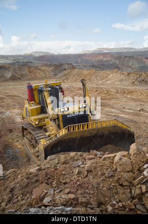 Un massiccio giallo komatsu bulldozer spinge rifiuti rock e terreno in un grande cast aperto di rame e di golf miniera in Zambia, Africa. Foto Stock