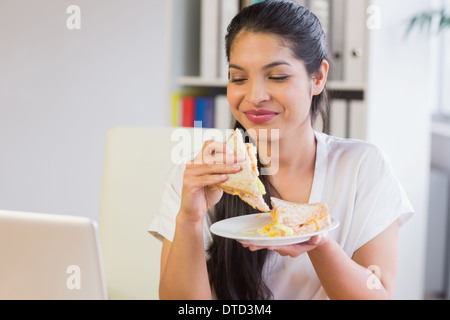 Imprenditrice mangiare panino in pausa pranzo Foto Stock