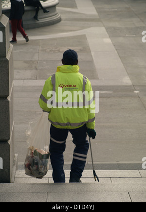 Un lavoratore del consiglio la raccolta di rifiuti in un sacchetto con un prelevamento griffa in Trafalgar Square, Londra Foto Stock