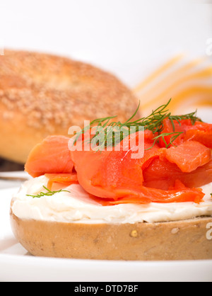 Deliziosa preparata di fresco bagel con formaggio cremoso, salmone affumicato, aneto e servita con succo d'arancia fresco Foto Stock