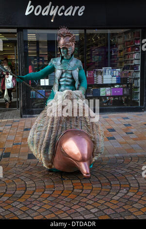 Blackpool, Lancashire, Regno Unito 15 Febbraio, 2014. I tritoni con i delfini - Mare dèi, coloratissime Mermen pattugliare le onde a cavallo di loro squirting dolphin carri a Blackpool il festival del circo, magic & nuova varietà artisti di strada. Foto Stock