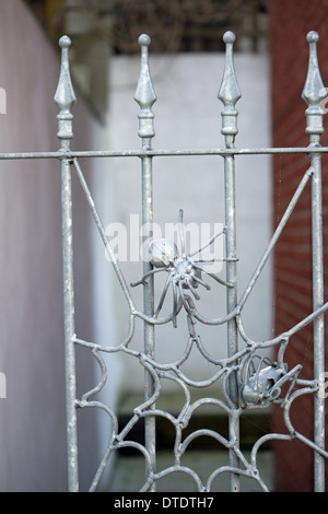 Metallo Scultured spider web e sulle ringhiere. Foto Stock