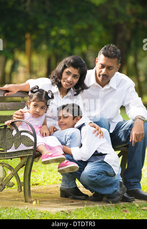 Famiglia indiana in panchina nel parco Foto Stock
