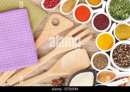 Varie spezie e di selezione utensili da cucina sul tavolo di legno Foto Stock