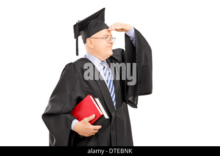 Collegio maschile professore in abito di graduazione cercando con la mano sopra gli occhi Foto Stock