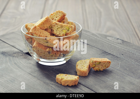 Fresh cantuccini con pistacchi in recipiente di vetro su sfondo di legno Foto Stock