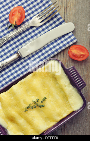 Cannelloni con ricotta e spinaci in una teglia su sfondo di legno Foto Stock