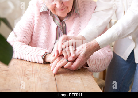 Close-up di mani di donna matura tenendo le mani della donna anziana Foto Stock