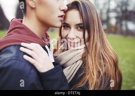 Bella ragazza adolescente con il suo fidanzato nel parco. Razza mista coppia giovane in amore all'esterno. Foto Stock