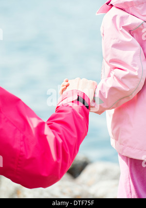 Close up della bambina e donna tenendo le mani in impostazione della natura Foto Stock
