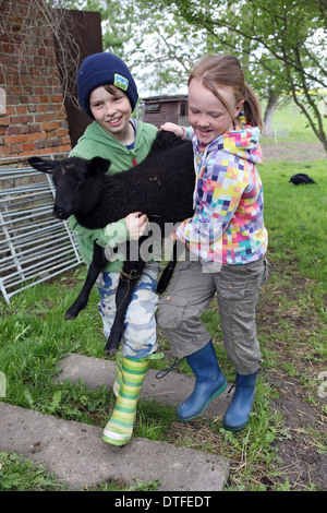 Nuovo Kätwin, Germania, un ragazzo e una ragazza che indossa un agnello nero Foto Stock