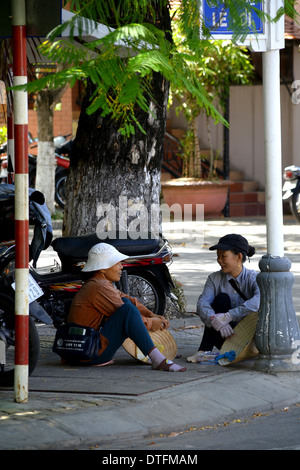 Il vietnamita le donne sedute a angolo di strada in chat Foto Stock