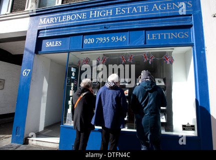 Le persone anziane alla ricerca di agenti immobiliari finestra, Marylebone High Street, Londra Foto Stock