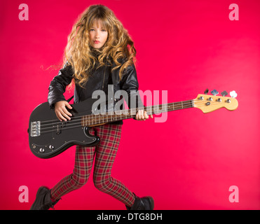 Blonde rock and roll girl suonare chitarra basso su sfondo rosso Foto Stock