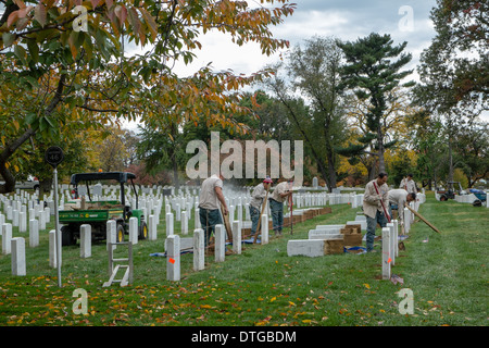 I dipendenti della Al Cimitero Nazionale di Arlington, potenza di lavaggio e rimuovere le lapidi in ordine al livello del suolo. Foto Stock