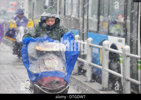 Changsha, provincia cinese di Hunan. 18 Febbraio, 2014. Un uomo corse nella neve in Changsha, capitale della centrale provincia cinese di Hunan, Feb 18, 2014. Credito: lunga Hongtao/Xinhua/Alamy Live News Foto Stock